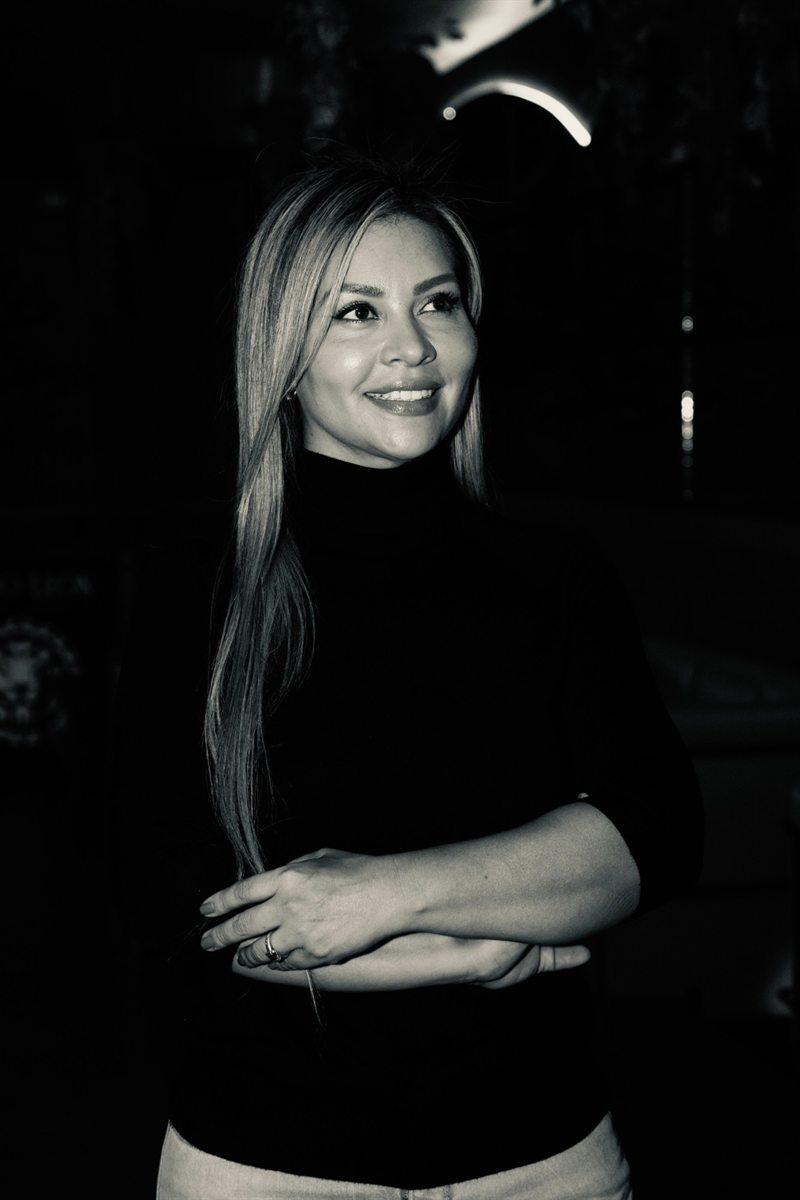 Retrato en blanco y negro de Lina Hernández con los brazos cruzados, sonriendo